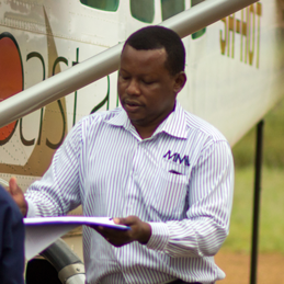 Camp Logistics Staff taking notes next to an aircraft.