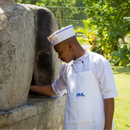 Picture of a man cooking on a stone barbeque.